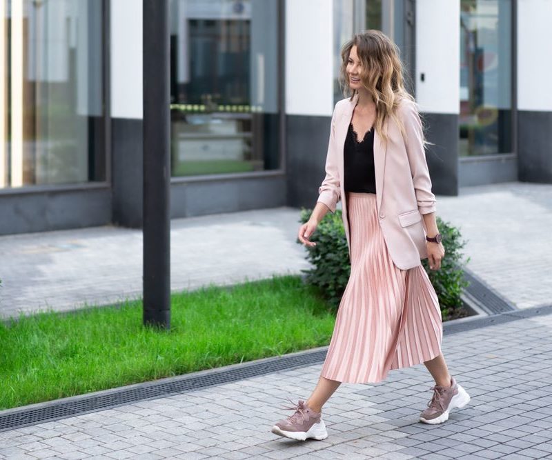 bezvremenske suknje koje treba da budu u garderobi svake žene; elegantna u plisiranoj suknji, patikama i blejzeru hoda ulicom