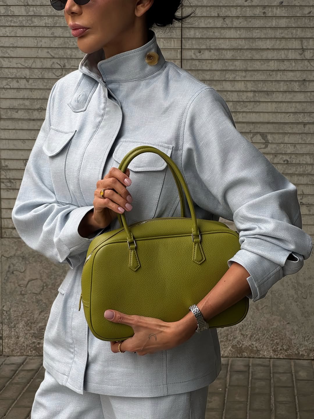Influenserka nosi kožnu torbu u zelenoj boji kao modni akcenat